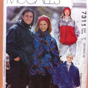 May include: A sewing pattern for three different jackets. The pattern is called McCall's 7311 and is for sizes Small, Medium, and Large. The jackets are shown on three models, one wearing a blue and black patterned jacket, one wearing a red and grey jacket, and one wearing a blue jacket.