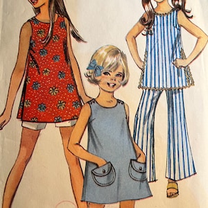 May include: A vintage sewing pattern featuring three girls wearing different dresses. The girl on the left is wearing a red sleeveless dress with a floral print. The girl in the middle is wearing a blue sleeveless dress with two pockets. The girl on the right is wearing a blue and white striped sleeveless dress with matching pants. The pattern number is 564.