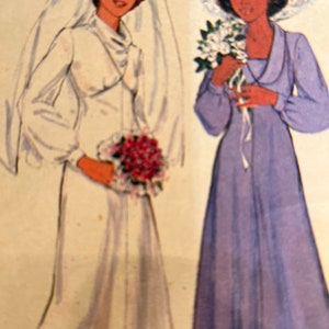 May include: Two women in wedding attire. The woman on the left is wearing a white gown with a long veil and holding a bouquet of red flowers. The woman on the right is wearing a lavender gown with a white hat and holding a bouquet of white flowers.