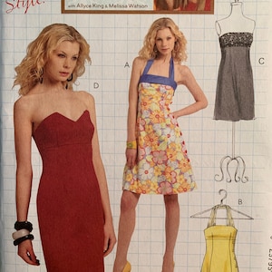 Könnte beinhalten: Ein Schnittmuster für drei verschiedene Kleider. Das erste Kleid ist ein rotes, trägerloses Kleid. Das zweite Kleid ist ein gelbes Halfterkleid mit Knöpfen vorne. Das dritte Kleid ist ein Kleid mit Blumendruck und Halfter.