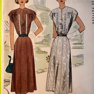 May include: Vintage printed pattern featuring two women's dresses. One dress is brown with a green belt, the other is gray with a black belt. Both dresses have short sleeves and button-up fronts. The dresses are illustrated in a classic, retro style.