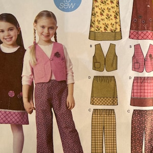 May include: A sewing pattern for girls' clothing, featuring a dress, vest, skirt, and pants. The dress has a floral print top and a contrasting hem. The vest is pink with a floral embellishment. The pants are patterned.