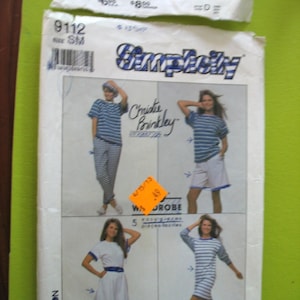 Puede incluir: Patrón de costura Simplicity número 9112 para un armario de cinco piezas. El patrón incluye una blusa y pantalones cortos a rayas, un vestido a rayas y un vestido blanco con ribete azul. El patrón es para talla pequeña.