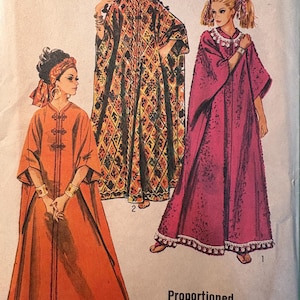 May include: A vintage sewing pattern featuring three women wearing different styles of long, flowing robes. The robes are in various colors and patterns, including orange, red, and a colorful geometric design. The pattern is labeled "One Size" and "Proportioned to your Height".