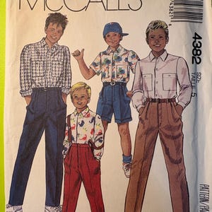 May include: McCall's pattern envelope showing illustrations of four young boys in different outfits. The boys are wearing button-down shirts, trousers, and shorts. The envelope is a light green colour with the McCall's logo and pattern number 4382.