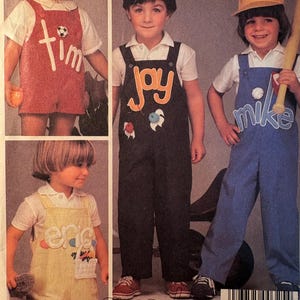 Op de afbeelding: Vintage patroon voor kinderoveralls met vier kinderen in overalls van verschillende kleuren. Elke overall heeft een naam: Tim, Jay, Mike en Eric. Het patroon is voor McCall's en bevat de tekst "namesakes for McCall's".