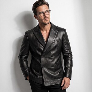 May include: A black double-breasted leather blazer featuring wide lapels, long sleeves, and a button-front closure. The jacket has a smooth, polished finish with visible seams and a structured fit, paired with dark trousers and round-frame glasses.