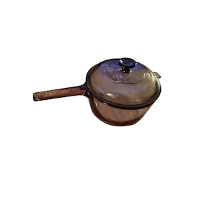 Cacerola de vidrio ámbar vintage Corning Visions con tapa y asa integrada.