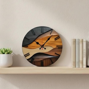 May include: A round wooden wall clock with a layered design. The clock face features a wave-like pattern in shades of black, brown, tan, and orange. Black hands and hour markers are visible. The clock is on a wooden shelf with a small potted plant and books.