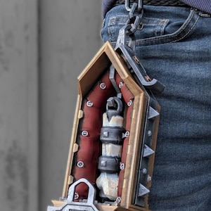 Pode incluir: Um acessório de lanterna em estilo gótico com uma moldura dourada envelhecida, um forro interior vermelho escuro e um elemento central de pilar branco com tachas de metal escuro. A lanterna pende de uma corrente cinzenta escura com interruptor.