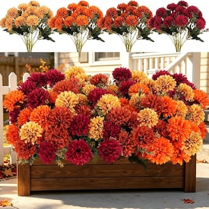 May include: A rectangular wooden planter box filled with a dense arrangement of artificial chrysanthemum flowers in shades of yellow, orange, rust, and deep burgundy, featuring green stems and leaves, with four separate flower bouquets shown above.