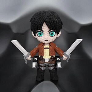 May include: A handmade, knitted figurine of a character with black hair and teal eyes, wearing a brown jacket, tan shirt, and gray pants. The figure is holding two silver swords. The figure is standing on a black surface.