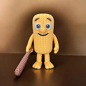 May include: A handmade, yellow knitted figure with a smiling face, blue eyes, and a brown bat. The figure has a textured, ribbed design and is standing upright. The bat is brown and has a similar knitted texture.