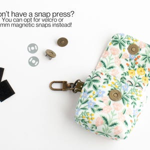 May include: A small, floral-patterned pouch with a metal clasp and magnetic snaps. The pouch is open, revealing its interior. Two pieces of velcro and two magnetic snaps are also visible. Text reads: "Don't have a snap press? You can opt for velcro or 14mm magnetic snaps instead!"