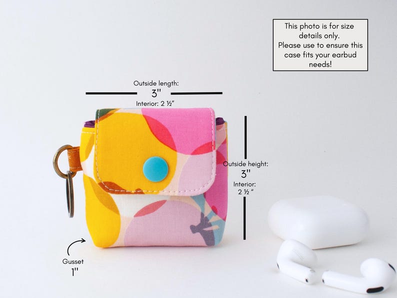 May include: A colorful fabric earbud case with a flap closure and a blue button. The case is 3 inches long, 3 inches high, and has a 1-inch gusset. The interior is 2.5 inches. The case has a key ring and is decorated with a vibrant floral pattern.