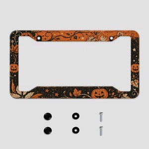 May include: A rectangular license plate frame featuring a black and orange design with illustrations of jack-o'-lanterns, autumn leaves, vines, and small stars. The set includes two black screw covers, two black washers, and two silver metal screws.