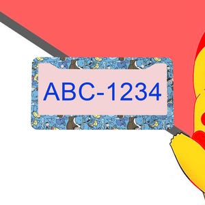 May include: A rectangular license plate frame featuring a repeating pattern of blue turtle-like creatures on a light blue background. The center of the frame is a light pink rectangle displaying the blue alphanumeric text ABC-1234.