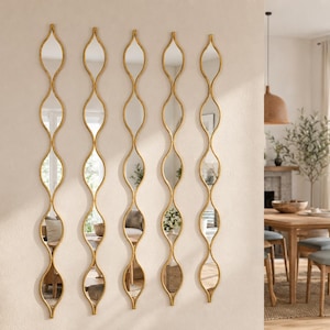 May include: Five vertical wall mirrors with gold-toned frames, each featuring a repeating wave or hourglass-shaped design. The mirrors are arranged in a parallel row, creating a continuous, elongated, and decorative reflective display.