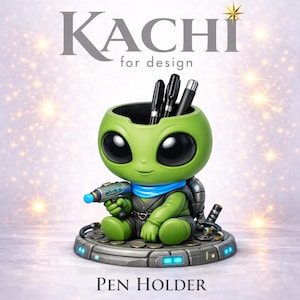 May include: Green alien-shaped pen holder with large black eyes, holding a ray gun. The pen holder has a round opening for pens and pencils. The base is gray with blue lights and the text "PEN HOLDER". The top text says "KACHI for design".