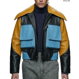 May include: A color-blocked leather jacket featuring a mustard yellow collar and sleeves, a black central panel, and two light blue flap pockets. The jacket is worn over a navy blue ribbed turtleneck sweater and grey trousers. The logo for The European Hide is visible in the top right corner.