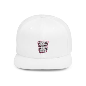 May include: A white baseball cap with a flat brim. The cap features the text "YOUR DREAMS ARE NOT ACCIDENTS THEY ARE REMINDERS OF WHO YOU CAN BECOME" in a graffiti-style design with pink, black, and blue accents.