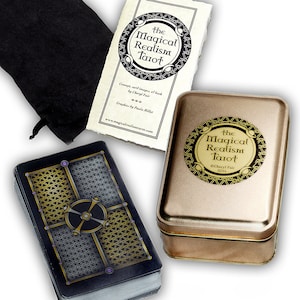 May include: A gold and black tin box with a black velvet bag and a deck of tarot cards. The tin box has the text "The Magical Realism Tarot" and "Cheryl Fair 2014". The cards have a gold and black geometric design.