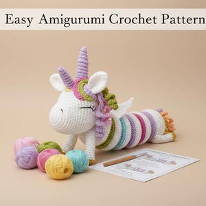 Peut inclure: Une licorne blanche crochetée avec une corne, une crinière et une queue violettes, couchée sur le côté. La licorne a un corps rayé aux couleurs pastel. L'image comprend des pelotes de laine de différentes couleurs et un crochet, avec le texte "Easy Amigurumi Crochet Pattern".