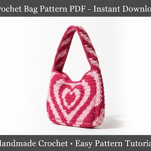 Peut inclure: Sac au crochet rose et blanc avec un motif de cœur. Le sac présente un motif de cœur rayé et une anse assortie. Le texte "Crochet Bag Pattern PDF - Instant Download" et "Handmade Crochet • Easy Pattern Tutorial" sont visibles. Article fait main.