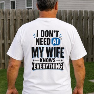 Peut inclure: Un t-shirt blanc à manches courtes avec un texte noir et bleu au dos indiquant I DON'T NEED AI MY WIFE KNOWS EVERYTHING. Le motif comprend une icône de bulle de dialogue bleue contenant les lettres AI et des accents en forme d'étoile.