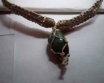 May include: A beige macrame necklace with a green stone pendant. The necklace is decorated with small blue and green beads.