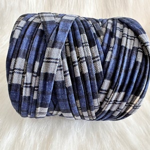 May include: A roll of blue and white plaid yarn. The yarn is made of fabric scraps and is perfect for crafting.