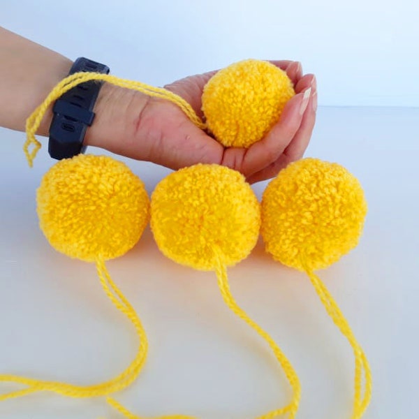 4 pompons en fil moutarde, 2 pompons en laine, gros pompons en laine