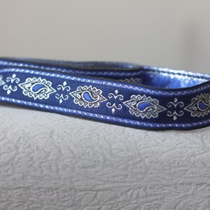 Puede incluir: Cinta azul y plateada con dise&ntilde;o de paisley.