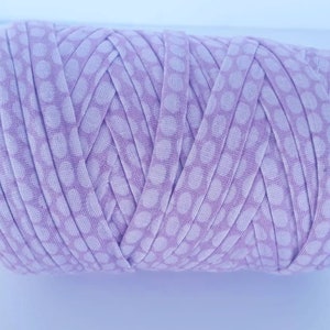 May include: A roll of light purple yarn with a white polka dot pattern.