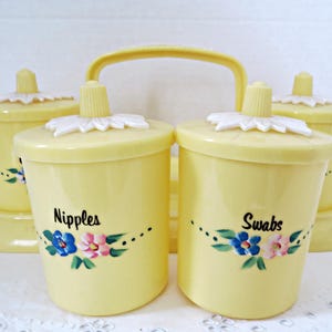 May include: A set of three ceramic mugs with a speckled, matte finish. The mugs are in shades of cream, light gray, and dark gray. Each mug has a simple, minimalist design and a rounded handle.