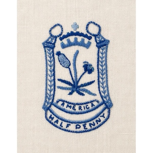 Bordado de lino azul estilo vintage con escudo americano y medio centavo.