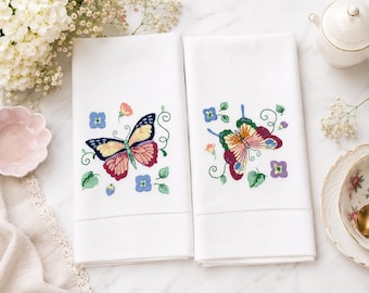 Paños de cocina vintage de algodón blanco con coloridos diseños de mariposas primaverales bordadas.