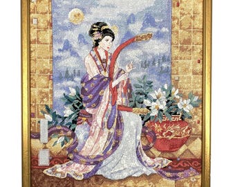 Cuadro antiguo enmarcado de punto de aguja oriental con geisha y flores, ideal para colgar en la pared.