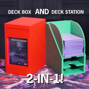 May include: A red deck box and a green deck station are displayed. The deck box has a card visible in a window. The deck station holds a stack of purple cards. The text "DECK BOX AND DECK STATION" and "2-IN-1!" are visible.