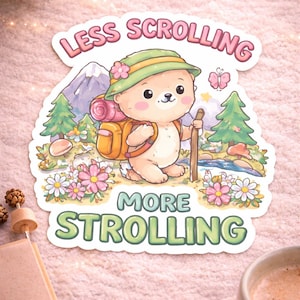 May include: A sticker with a cartoon bear wearing a hat and backpack, holding a walking stick. The sticker has the text "LESS SCROLLING MORE STROLLING" in pink and green. The bear is in a forest scene with flowers and a mountain.