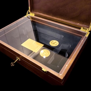 May include: A wooden display case with a clear acrylic top, showcasing gold coins and a gold card. The case has brass hinges and a lock. The interior features a black velvet lining, providing a luxurious presentation for collectibles.