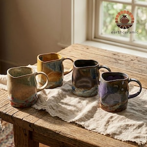 May include: A set of three ceramic mugs with a speckled, matte finish. The mugs are in shades of cream, light gray, and dark gray. Each mug has a simple, minimalist design, perfect for coffee or tea.