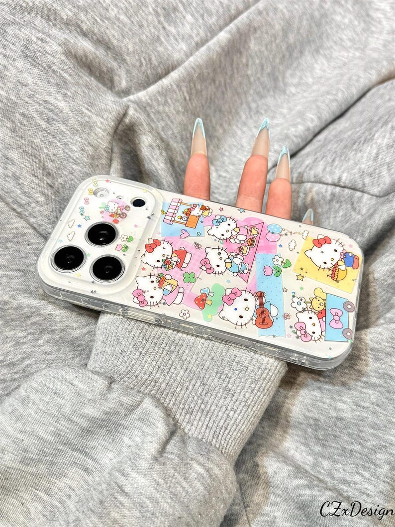 May include: Clear phone case featuring a colorful collage of Hello Kitty characters. The case has a white border and a clear back, showcasing the phone's design. The design includes various scenes with Hello Kitty, musical instruments, and other cute elements.