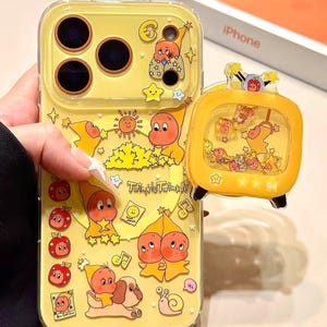 Puede incluir: Funda amarilla para iPhone con gráficos de gnomos y estrellas de dibujos animados. La funda tiene un pop-socket a juego con forma de televisión. El texto "Twinkle Twinkle" está impreso en la funda. La funda está diseñada para un iPhone.