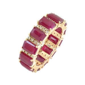 May include: A gold ring featuring rectangular, deep red gemstones and small, clear accent stones. The ring's design showcases a repeating pattern of the red stones, with the accent stones adding a touch of sparkle. The ring is set against a white background.