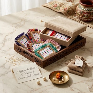 Peut inclure: Une collection de cartes bindi rectangulaires à pois colorés et bordures à franges, rangées dans un plateau en bois avec une boîte beige. Comprend une petite pochette beige, une coupelle en laiton avec un souci et une carte A Gift for the Bride.