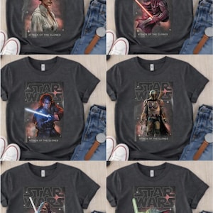 May include: Six dark gray t-shirts featuring Star Wars characters and the text "STAR WARS" and "ATTACK OF THE CLONES". The shirts display images of Princess Leia, Darth Vader, Anakin Skywalker, Boba Fett, Chewbacca, and Grogu.
