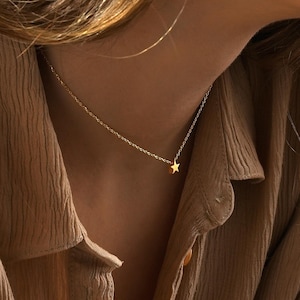 May include: A set of three ceramic mugs with a speckled, matte finish. The mugs are in shades of cream, light gray, and dark gray. Each mug has a simple, minimalist design, perfect for coffee or tea.