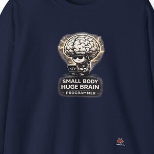 Puede incluir: Sudadera azul marino con un dibujo animado de un cerebro con gafas de sol y un símbolo de código. El texto dice "SMALL BODY HUGE BRAIN - PROGRAMMER". La sudadera es de color liso y tiene mangas largas.