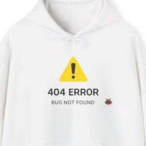 May include: White hooded sweatshirt with a front pocket and drawstring. The front features a yellow warning sign with the text "404 ERROR BUG NOT FOUND" and a small red ladybug graphic. A casual, comfortable garment.
